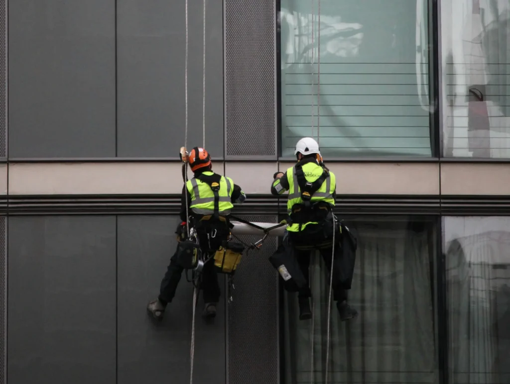 Montagearbeiten an einer Fassade mit Seilzugangstechnik – Höhenarbeiter Nico Ganzer und Matthias Olbort im Einsatz